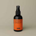 Minimalist product shot showcasing a natural spray deodorant in sleek amber packaging.